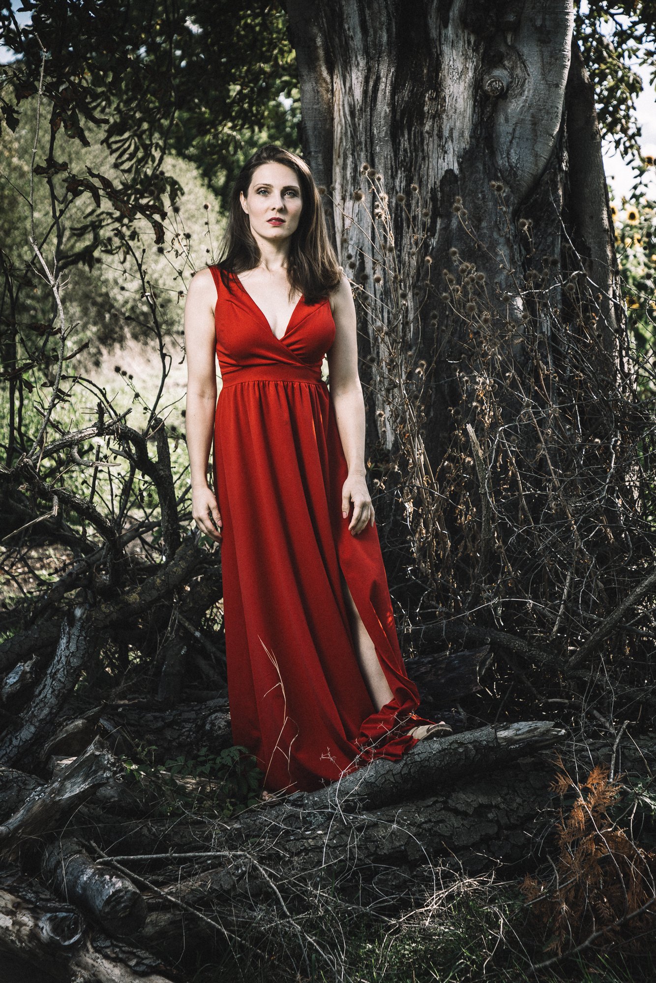 Nicole Tschaikin im roten Abendkleid vor einem alten Baum